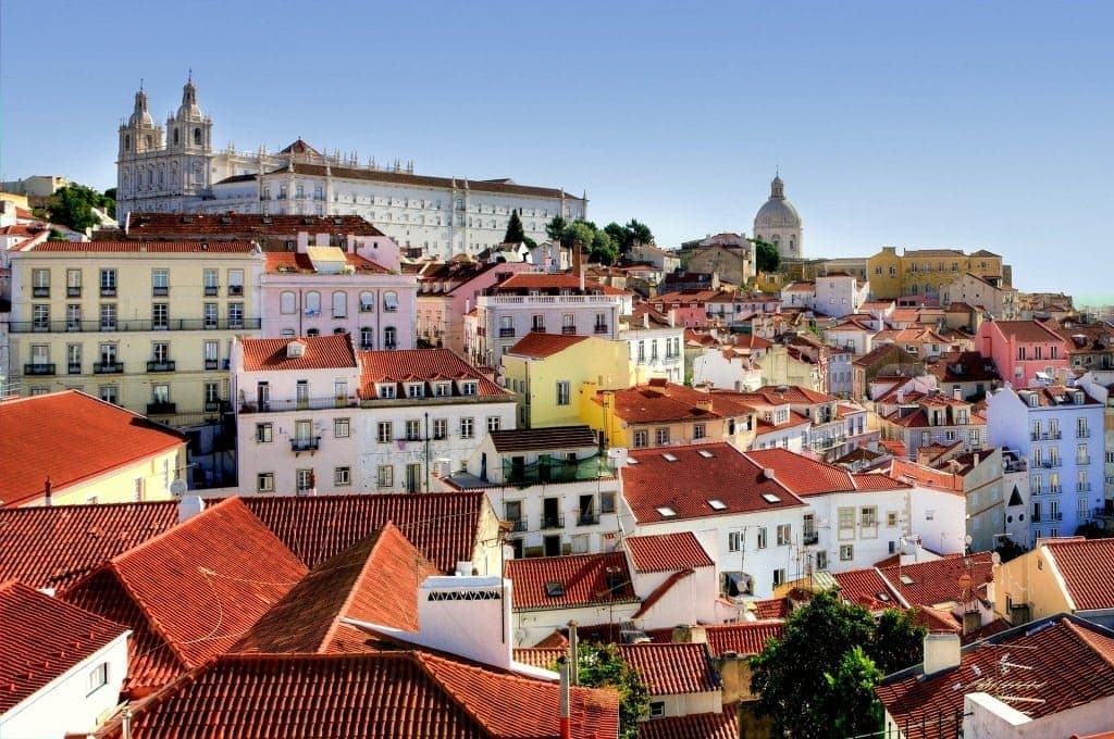 Tuk-tuk touring through Alfama's colorful narrow streets in Lisbon historic district